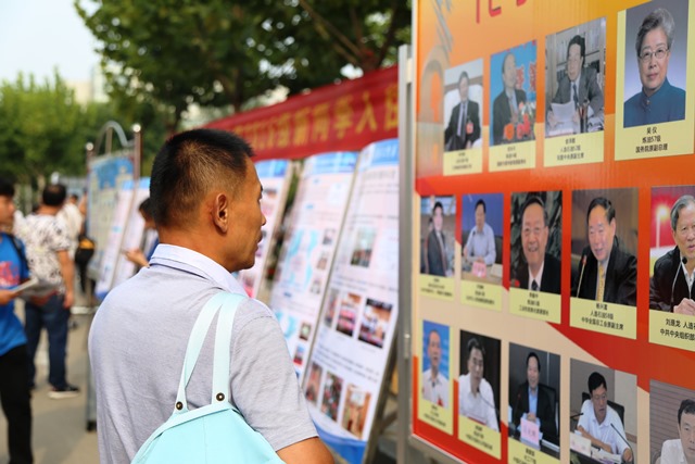 家长驻足观看公司杰出员工展 全运摄影 家长驻足观看公司杰出员工展 全运摄影